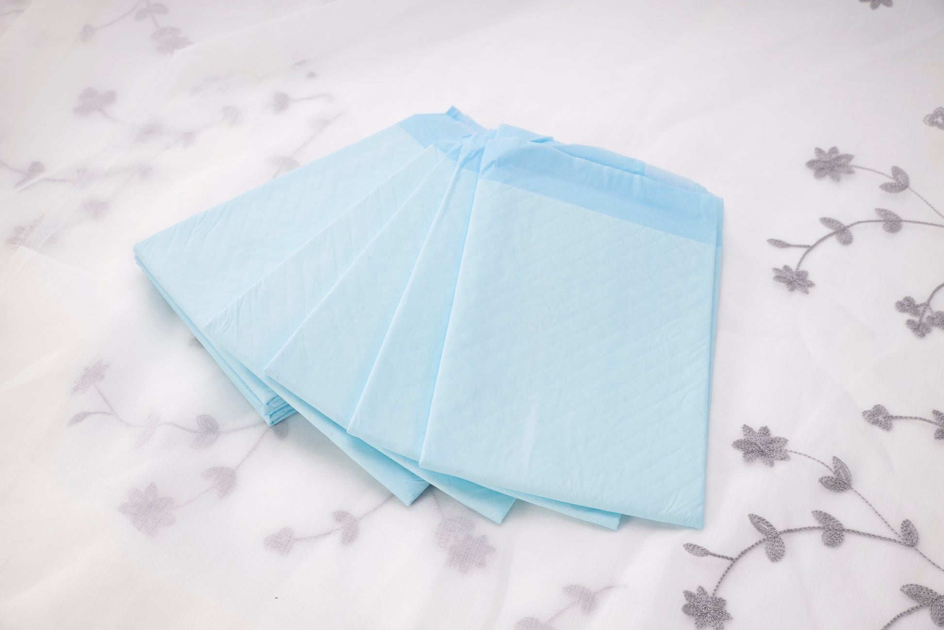 Stack of light blue underpads, folded square sheets