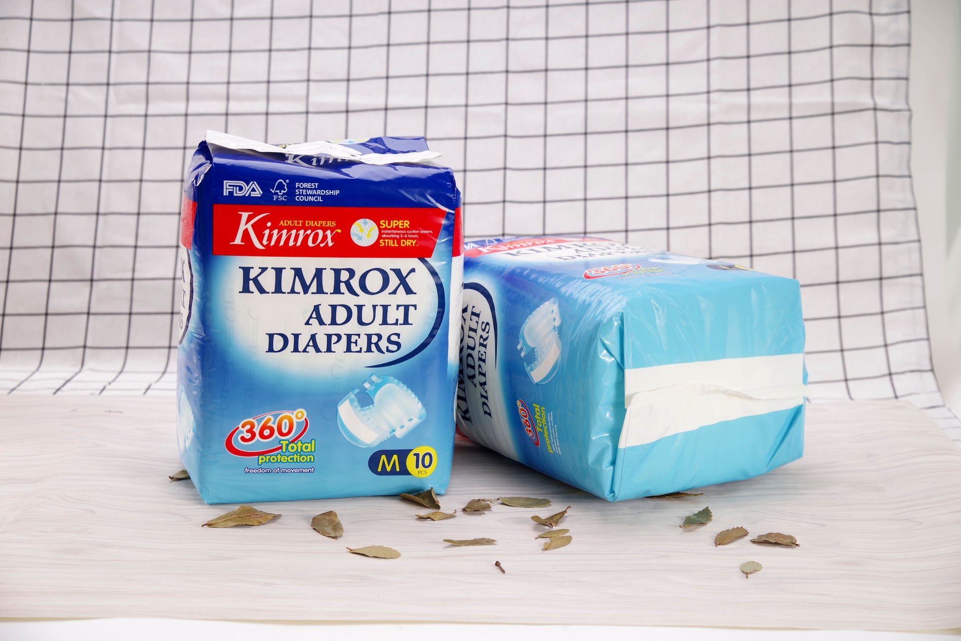 Kimrox adult diaper packs with scattered absorbent inserts on a table